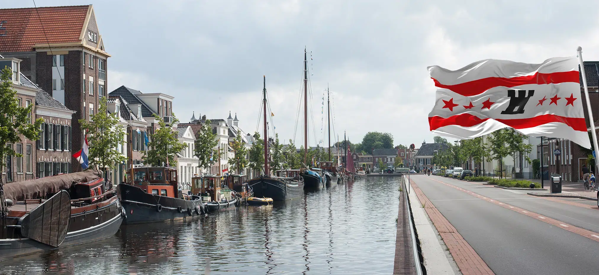 kanaal met boten en de vlag van drenthe